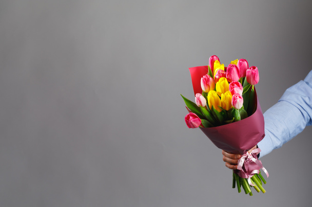 букет квітів тюльпанів в руці, сірий фон з копією простору
 - Фото, зображення