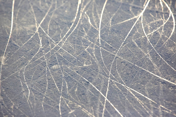 heldere sporen van schaatsen op een ijsbaan. achtergrond en textuur - Foto, afbeelding