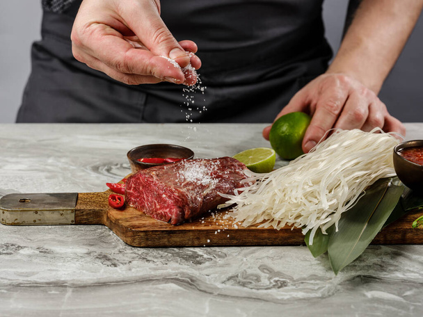 Asian food cooking - rice noodles with beef steak and mango chili sauce ingredients on white table background. - Fotografie, Obrázek