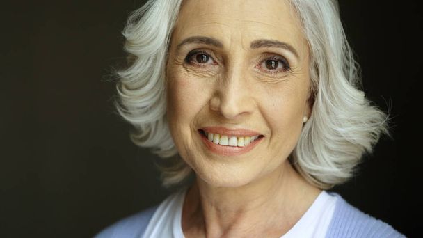 Close up portrait of beatiful old woman with grey hair smiling at camera. Indoor shot. Portrait shot. - Photo, Image
