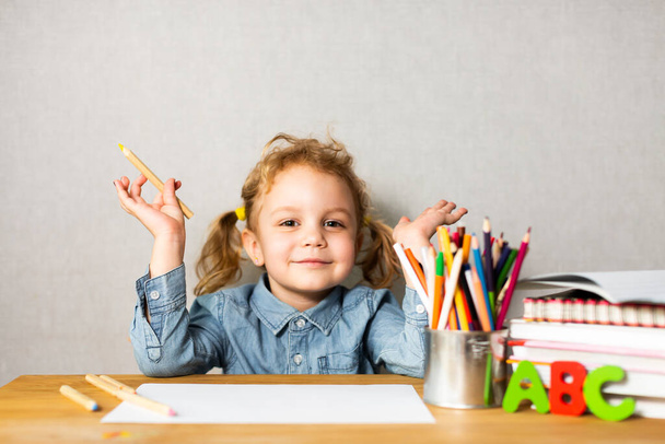 Cute European girl sits at school desk, concept of learning, back to school - Foto, Imagem