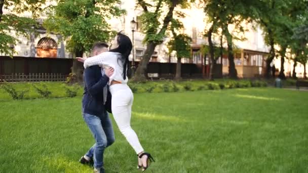 The couple is turning around on the spring lawn - Footage, Video