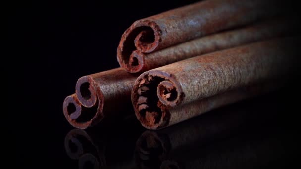 Slow rotation of cinnamon sticks on a black background - Footage, Video