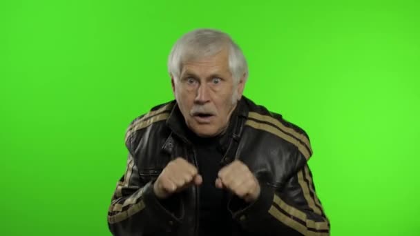 Älterer kaukasischer Großvater Rocker Mann zeigt Faustkampf. Chroma Key Hintergrund - Filmmaterial, Video
