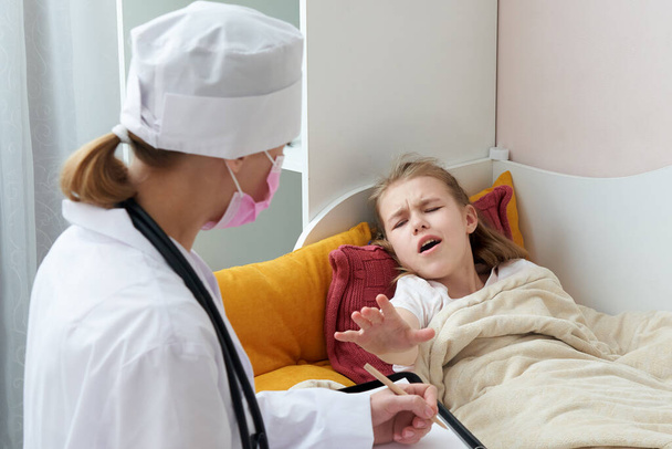 Lekarz odwiedzający chorą dziewczynkę w domu i wypisujący receptę, koncepcja spalin  - Zdjęcie, obraz
