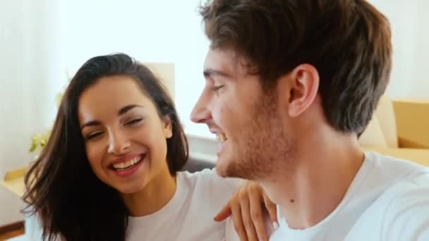 Young couple move into new apartment. Slow motion video of man and woman posing on camera and talking during video recording. Cheerful positive couple show their apartment and have fun together. - Footage, Video