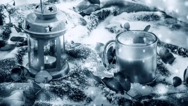 Świąteczna czerwona świeca latarnia kubek kawa czerwony dywan ze śniegiem zielone liście. - Materiał filmowy, wideo
