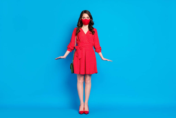 Full length photo of pretty lady keep social distance people walk outside breathe air wear dotted red short dress stilettos clutch bag protective facial mask isolated blue color background - Photo, Image