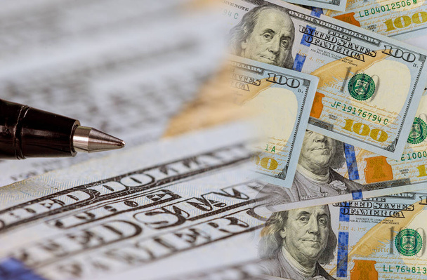 Caneta em muitas centenas de notas de dólar dos EUA em close-up de negócios
 - Foto, Imagem