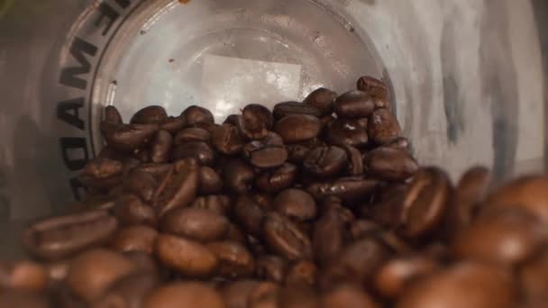 Roasted coffee beans background. Close-up of roasted coffee beans spinning slowly in a circle. Roasted coffee bean background, top view. - Metraje, vídeo