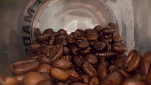 Roasted coffee beans background. Close-up of roasted coffee beans spinning slowly in a circle. Roasted coffee bean background, top view. - Materiał filmowy, wideo