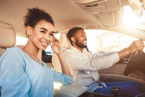 Feliz pareja negra conduciendo sentado en coche viajando de vacaciones
 - Foto, imagen
