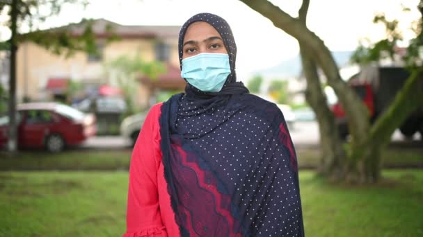 Молода мусульманка в медичній масці в саду. Медична допомога та медична допомога після кочівлі-19. - Кадри, відео