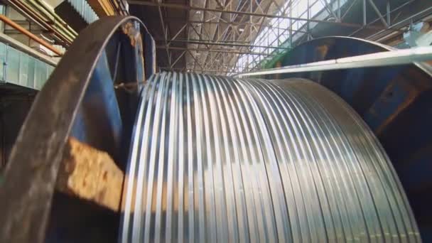 Un enorme bobina si snoda un filo in una fabbrica di cavi. I prodotti sono utilizzati nelle industrie dell'energia, dei trasporti, dell'edilizia, dell'ingegneria, del nucleare, della difesa, del petrolio e del gas
. - Filmati, video