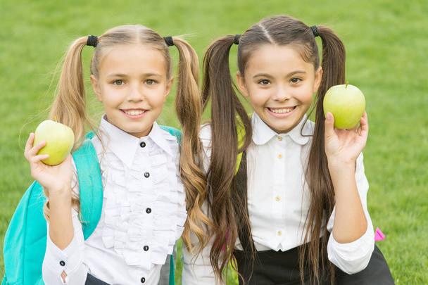おやつの休憩。幸せな子供たちは屋外で緑のリンゴを保持します。食事の後に果物を食べる。ベジタリアンフード。学校の休みだ。ベジタリアン。健康的な菜食主義の栄養。ベジタリアンの選択 - 写真・画像