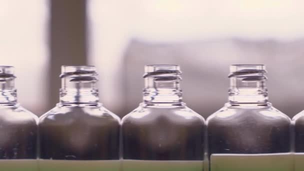 Prázdné plastové láhve na dezinfekci se pohybují podél dopravníkového pásu v továrně na výrobu osobních ochranných prostředků. - Záběry, video