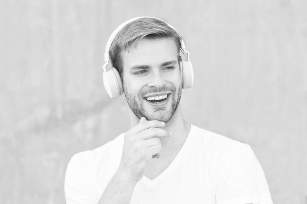 Noise Reduction. Wireless Earpiece. Handsome guy wear headphones grey background. Man listen modern music. Modern technology. Modern and contemporary music. Hobby leisure. Foldable Stereo Headphones - Photo, Image
