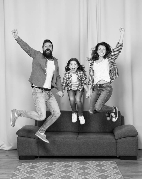 Good vibes. Positive emotions. Higher. Friendly family jump couch Mom dad and daughter relaxing. We are family. Happy family spend weekend together. Our home made for fun. Togetherness and bonds - Фото, зображення