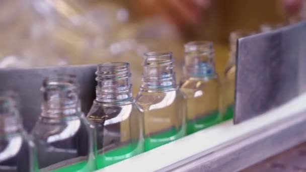 Bottiglie di plastica vuote per disinfettanti si muovono lungo il nastro trasportatore in fabbrica per la produzione di dispositivi di protezione individuale
. - Filmati, video