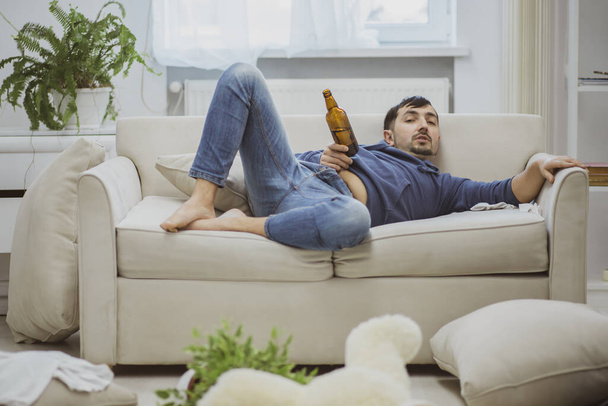A man doing nothing with a beer in hand. - Zdjęcie, obraz
