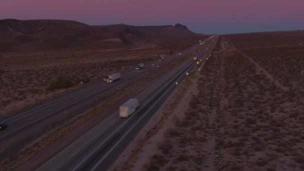 AERIAL: Lecąc za ciężarówką przewożącą ładunek przez pustynię Mojave o świcie - Materiał filmowy, wideo