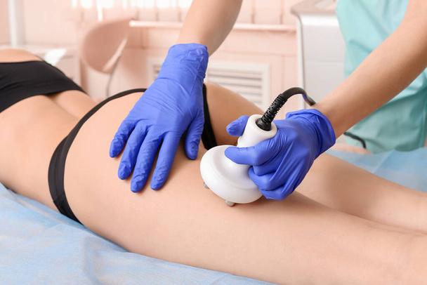 Young woman undergoing procedure of anti-cellulite treatment in beauty salon - Photo, Image