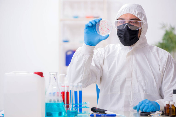 Молодой химик-мужчина, работающий в лаборатории медицины
 - Фото, изображение