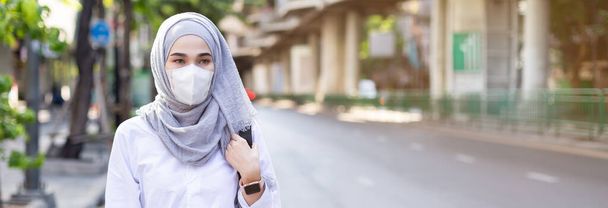 asiatico musulmano donna indossare medico maschera per prevenire polvere e infezione virus standing street side in city. Concetto di coronavirus (covid-19), dimensione banner ritaglio
. - Foto, immagini