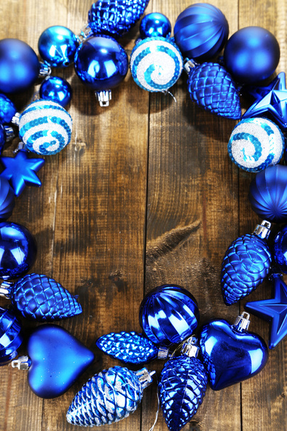 Рождественский венок из разноцветных шаров на деревянном столе крупным планом
 - Фото, изображение