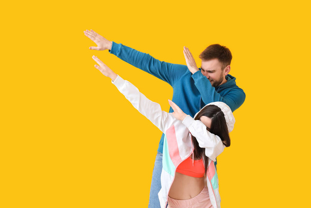 Happy young couple dancing against color background - Foto, Bild