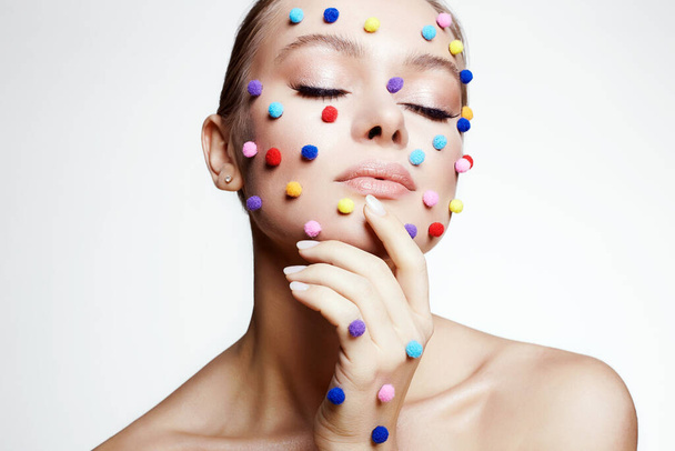 Beautiful young woman with colorful make-up. Beauty portrait of girl with colored balls makeup - Photo, Image