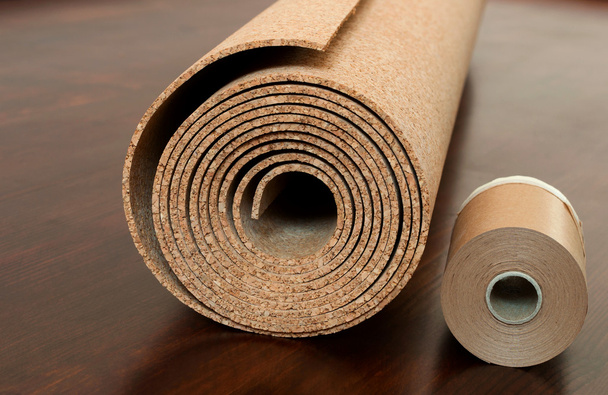 Rollo de corcho con cinta de borde de pintura en un piso marrón
 - Foto, imagen