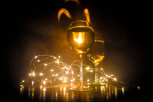 Goblet of wine on wooden table with beautiful toned lights on background. Glasses of wine on dark background. Selective focus. Club drink concept - Zdjęcie, obraz