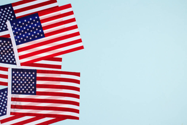 Vue de dessus sur la composition horisontale avec des drapeaux américains sur fond bleu clair avec copyspace. Symbole national des États-Unis - drapeau Old Glory. Concept de célébration du Jour de l'indépendance, du Jour commémoratif ou du Jour du drapeau
 - Photo, image