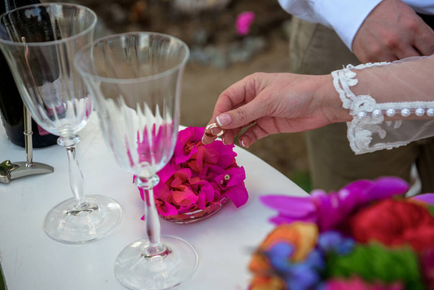Η νύφη βγάζει δαχτυλίδια από πέταλα λουλουδιών, από κοντά.. - Φωτογραφία, εικόνα