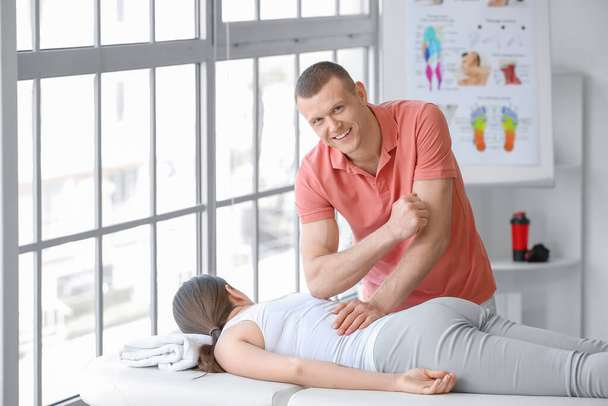 Massage therapist working with female patient in medical center - Foto, afbeelding