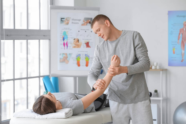Massage therapist working with female patient in medical center - Фото, зображення