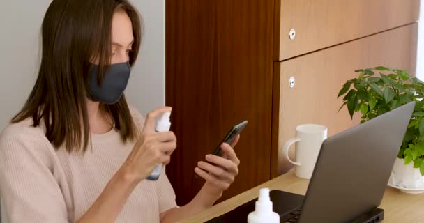 Mujer en el teléfono inteligente de desinfección máscara
 - Imágenes, Vídeo
