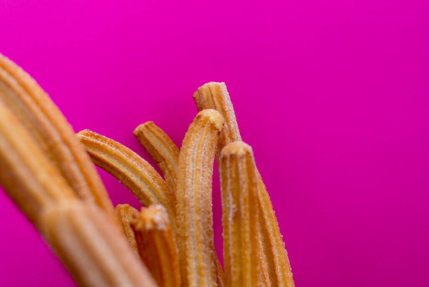 Churros sokerilla vaaleanpunaisella taustalla - Valokuva, kuva