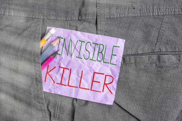 Conceptual hand writing showing Invisible Killer. Business photo text presence into the air of a substance which are harmful Writing equipment and purple note paper inside pocket of trousers. - Photo, Image
