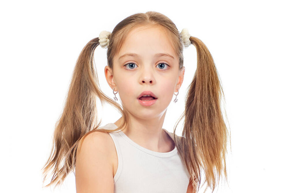 Νεαρό χαριτωμένο μπερδεμένο κορίτσι με γκρι μπλε μάτια και δύο ουρές μαλλιών που απομονώνονται σε λευκό φόντο - Φωτογραφία, εικόνα