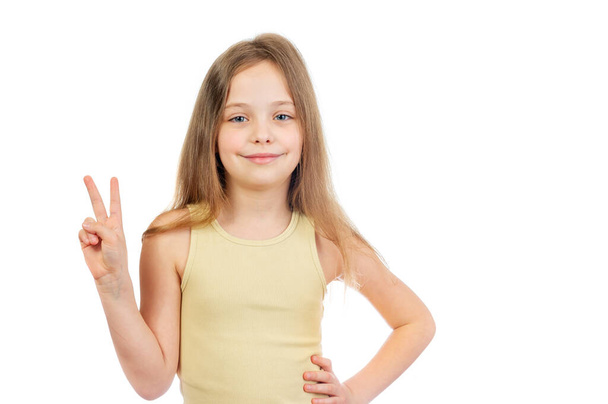 Young cute smiling  girl with long light brown hair shows victory sign isolated on white background - Photo, image