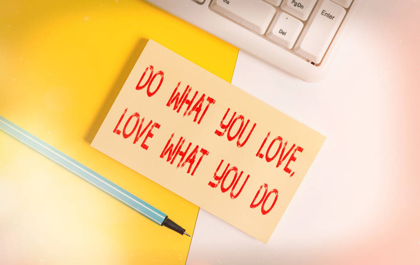 Концептуальный почерк, показывающий Do What You Love What You Do. Бумага с копировальным пространством и клавиатурой над оранжевым фоновым столом
. - Фото, изображение