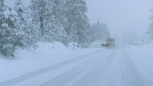 Náklaďák orá zasněženou venkovskou silnici během strašné sněhové bouře. - Záběry, video