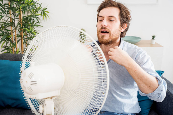 Ένα πορτρέτο άντρα που υποφέρει από καλοκαιρινή ζέστη στο σπίτι - Φωτογραφία, εικόνα
