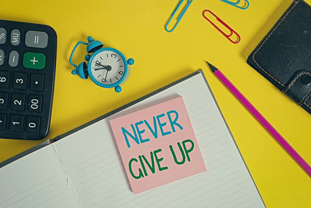 Text sign showing Never Give Up. Conceptual photo be persistent to keep on trying to improve the condition Notebook wallet calculator clips pencil note alarm clock color background. - Фото, зображення