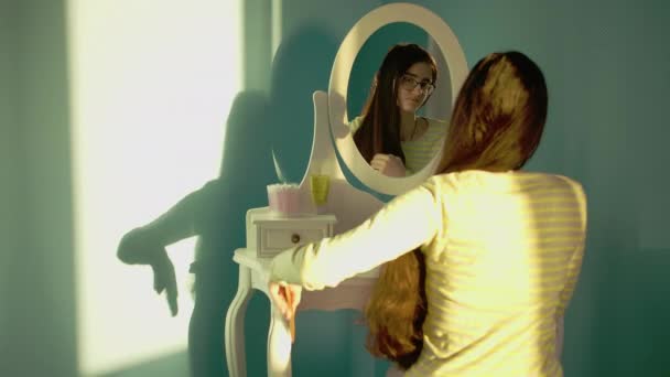 Підліток в окулярах з довгим густим волоссям, зачепленим сонячним днем перед дзеркалом
 - Кадри, відео