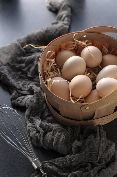 Farm fresh chicken eggs in a basket on a gray background - Photo, image