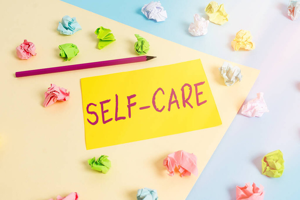 Handwriting text Self Care. Concept meaning the practice of taking action to improve one s is own health Colored crumpled papers empty reminder blue yellow background clothespin. - Photo, Image