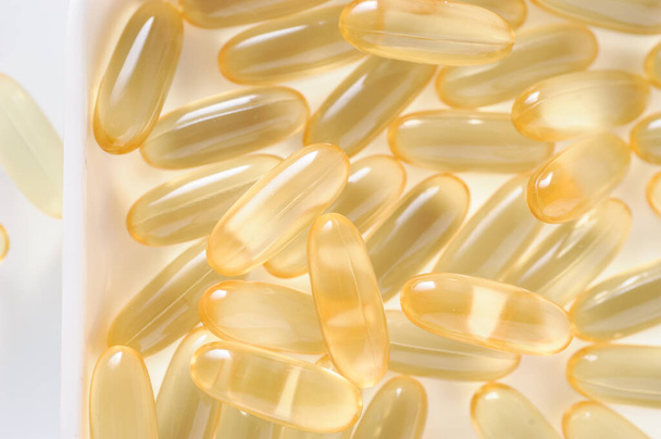 жовті таблетки риб'ячого жиру, омега 3
 - Фото, зображення
